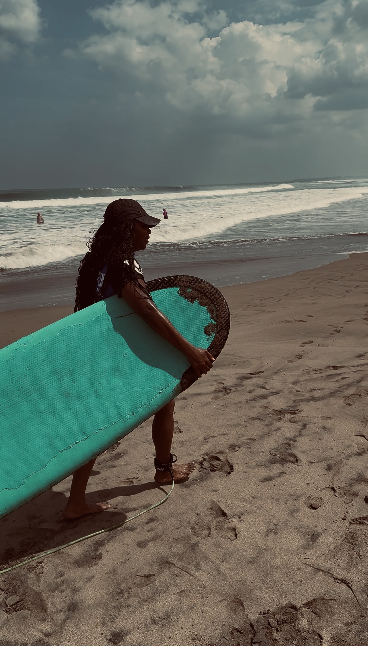 India carrying a surfboard to the ocean on a weekday